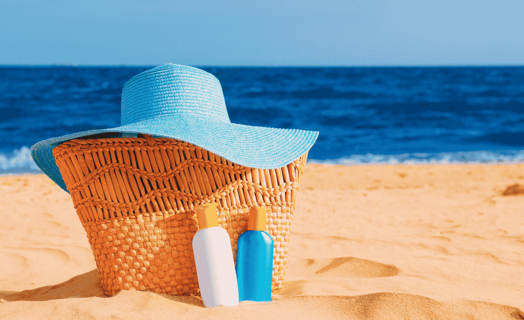 Beach bag, sun hat and sunscreen on a Caribbean beach
